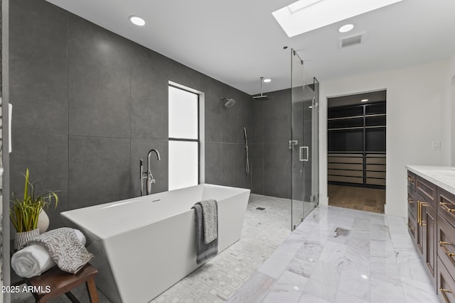 9611 E Clinton St, Scottsdale, AZ 85260 - bathroom with a skylight, a stall shower, a soaking tub, vanity, and recessed lighting