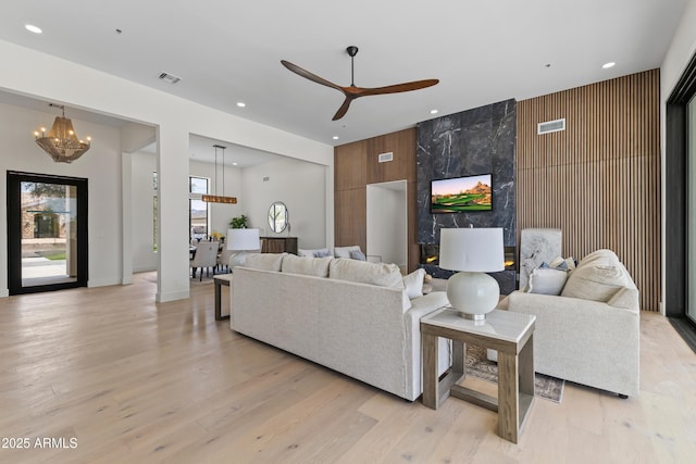 9611 E Clinton St, Scottsdale, AZ 85260 - living room with a chandelier, ceiling fan, light wood-style flooring, recessed lighting, and an accent wall