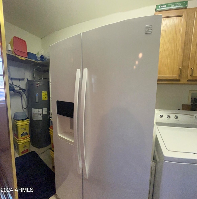 washroom featuring electric water heater, cabinets, and washer / clothes dryer