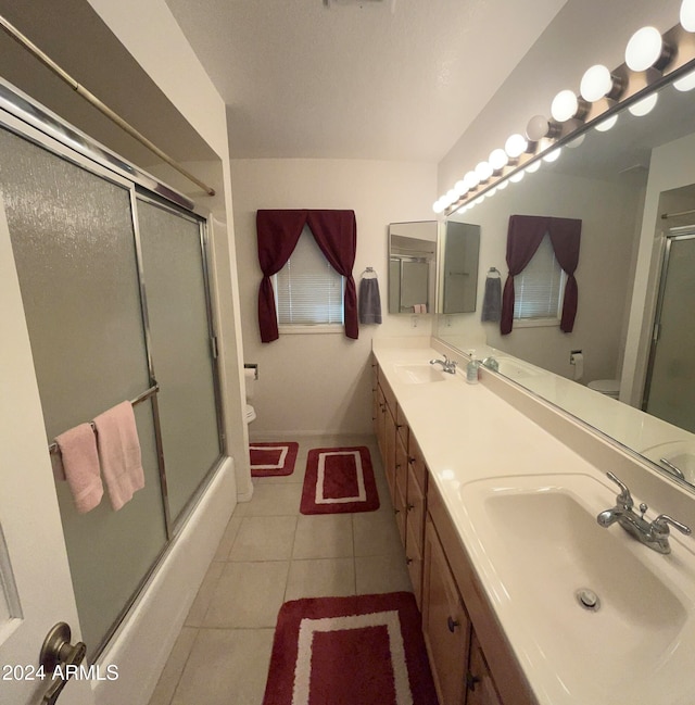 full bathroom with vanity, shower / bath combination with glass door, toilet, and tile patterned floors