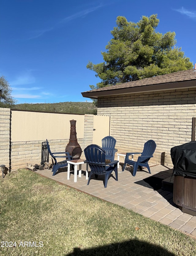 view of patio / terrace with a hot tub, area for grilling, and an outdoor fire pit