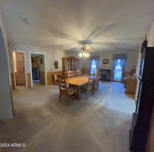 carpeted dining space with a textured ceiling and ceiling fan