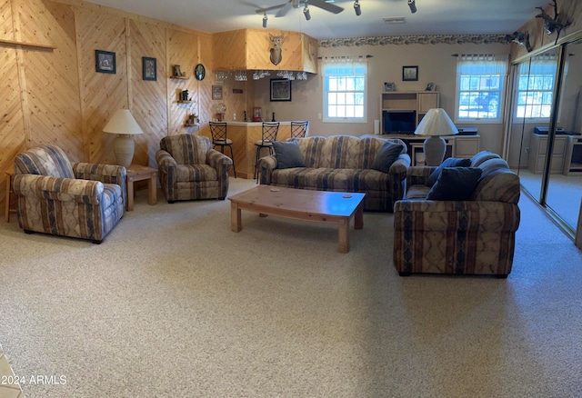 living room with ceiling fan and wooden walls