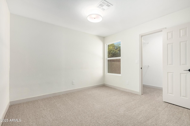 spare room with light carpet, visible vents, and baseboards