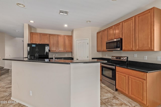 kitchen with light tile patterned floors, stainless steel appliances, and a kitchen island with sink