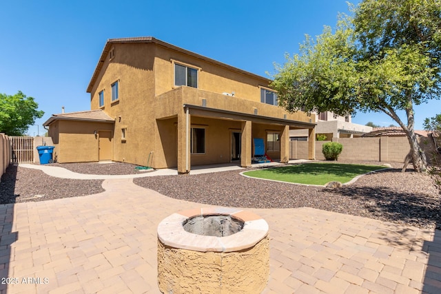 back of property with a patio area and an outdoor fire pit