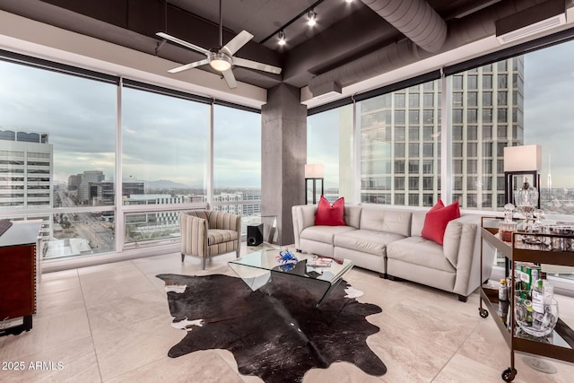 tiled living room featuring expansive windows, track lighting, and ceiling fan