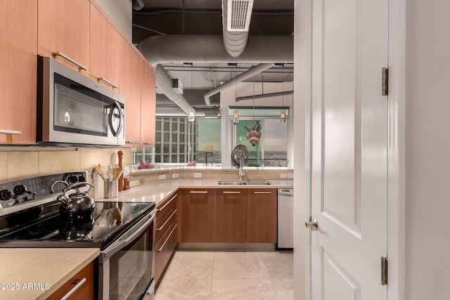 kitchen with tasteful backsplash, light tile patterned flooring, appliances with stainless steel finishes, and sink