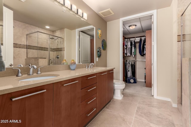 bathroom with an enclosed shower, vanity, tile patterned floors, and toilet