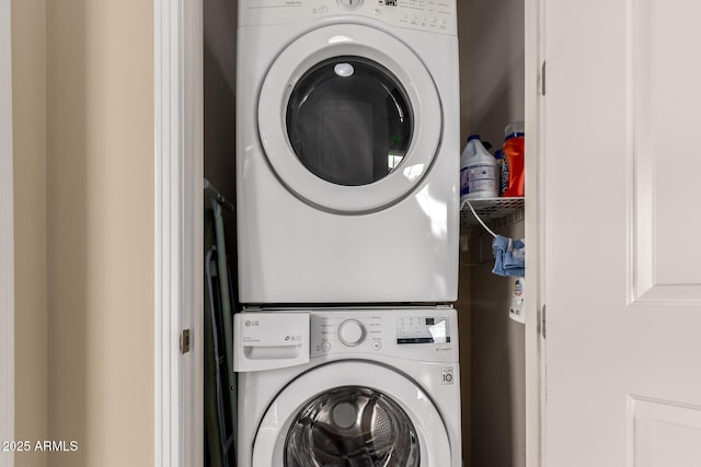 clothes washing area featuring stacked washing maching and dryer