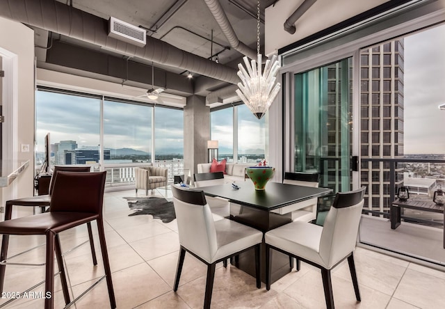 tiled dining area featuring an inviting chandelier and expansive windows