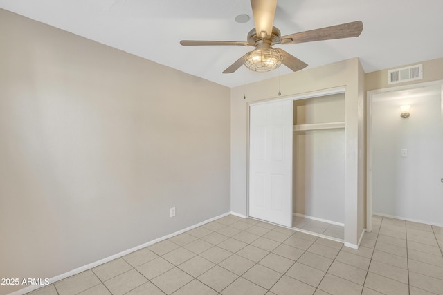 unfurnished bedroom with baseboards, visible vents, ceiling fan, a closet, and light tile patterned flooring