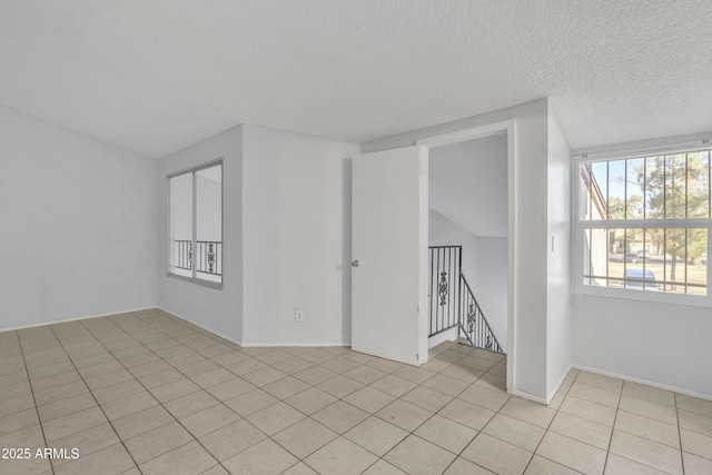 additional living space with a textured ceiling and light tile patterned flooring