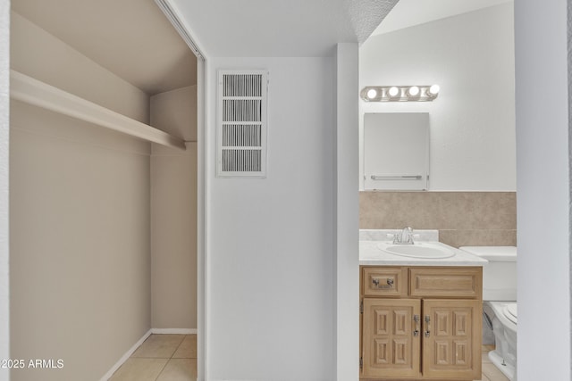 bathroom with visible vents, vanity, toilet, and tile patterned floors