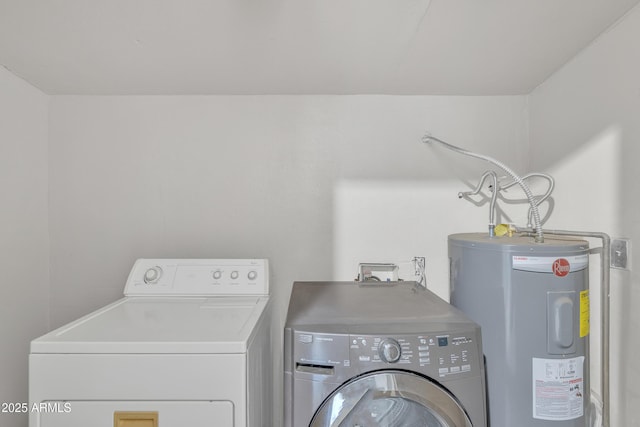 washroom featuring laundry area, washing machine and clothes dryer, and electric water heater