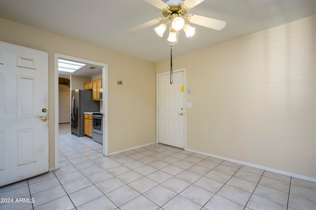 unfurnished room with light tile patterned floors and ceiling fan