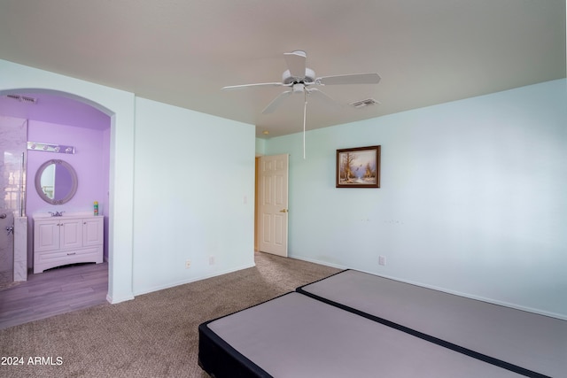 unfurnished bedroom with ceiling fan, connected bathroom, and carpet flooring