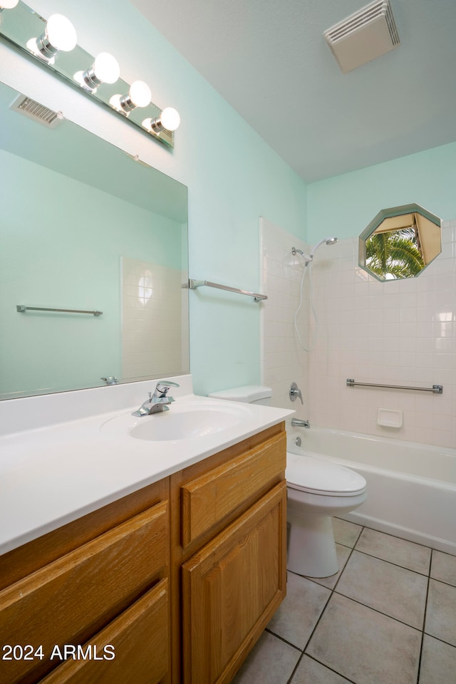 full bathroom with tile patterned flooring, vanity, tiled shower / bath combo, and toilet