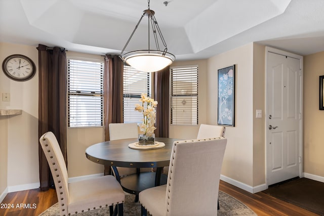 dining area featuring dark hardwood / wood-style floors and a raised ceiling