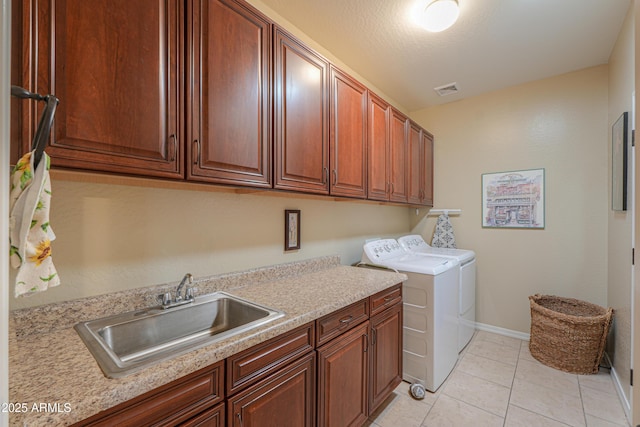 laundry area with a sink, visible vents, independent washer and dryer, cabinet space, and light tile patterned floors