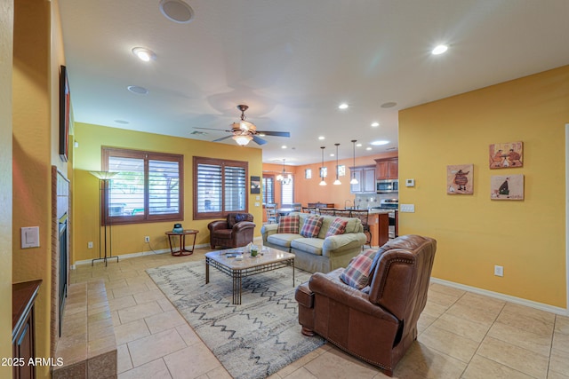 living area featuring ceiling fan, baseboards, and recessed lighting