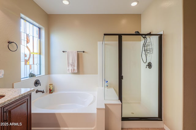 bathroom featuring recessed lighting, a shower stall, a garden tub, and vanity
