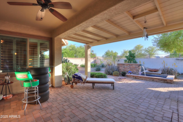 view of patio featuring fence and ceiling fan