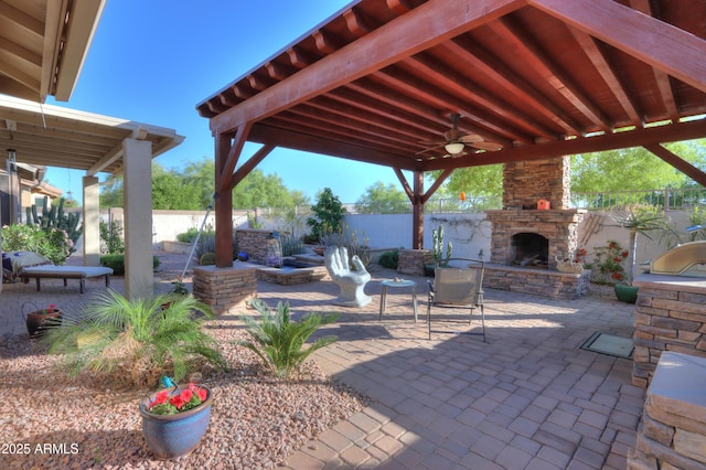 view of patio / terrace with a fenced backyard, a gazebo, an outdoor stone fireplace, and ceiling fan