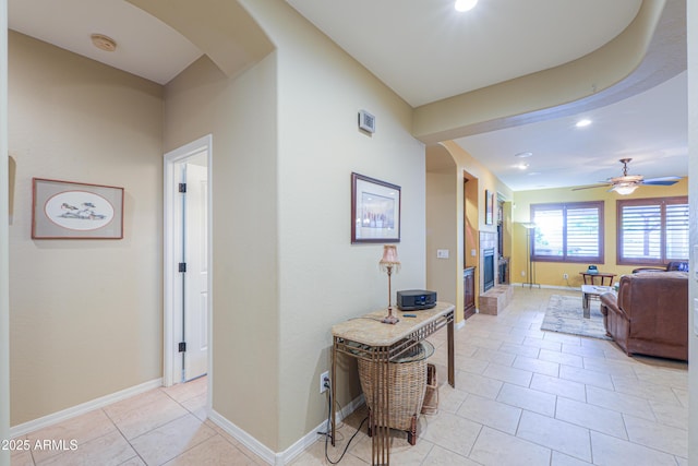 hall featuring recessed lighting, baseboards, and light tile patterned floors