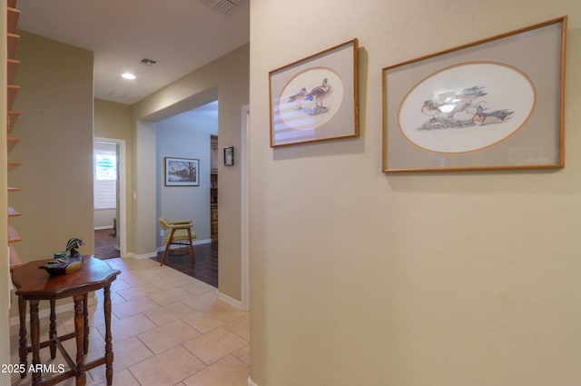 corridor with baseboards, light tile patterned flooring, visible vents, and recessed lighting