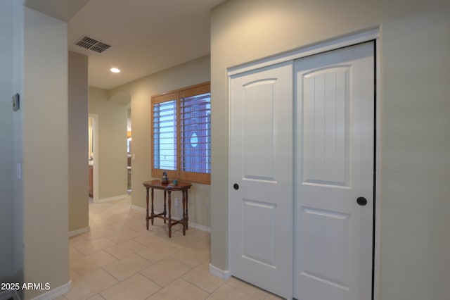 hallway with recessed lighting, visible vents, baseboards, and light tile patterned floors