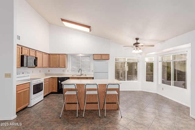 kitchen with vaulted ceiling, a breakfast bar, sink, a center island, and black appliances