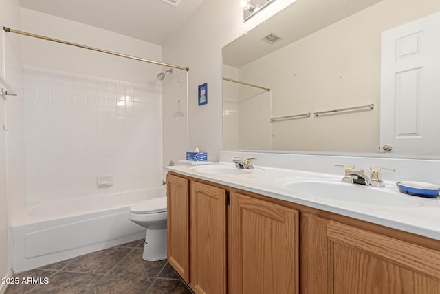 full bathroom featuring tile patterned flooring, vanity, tiled shower / bath combo, and toilet