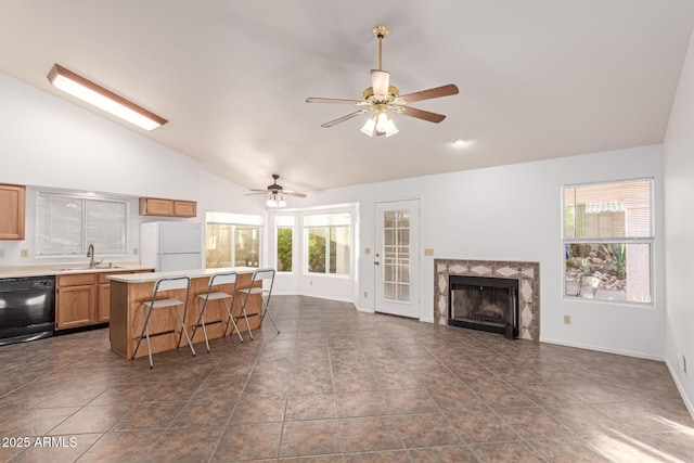 kitchen with dishwasher, lofted ceiling, a kitchen bar, white fridge, and a center island