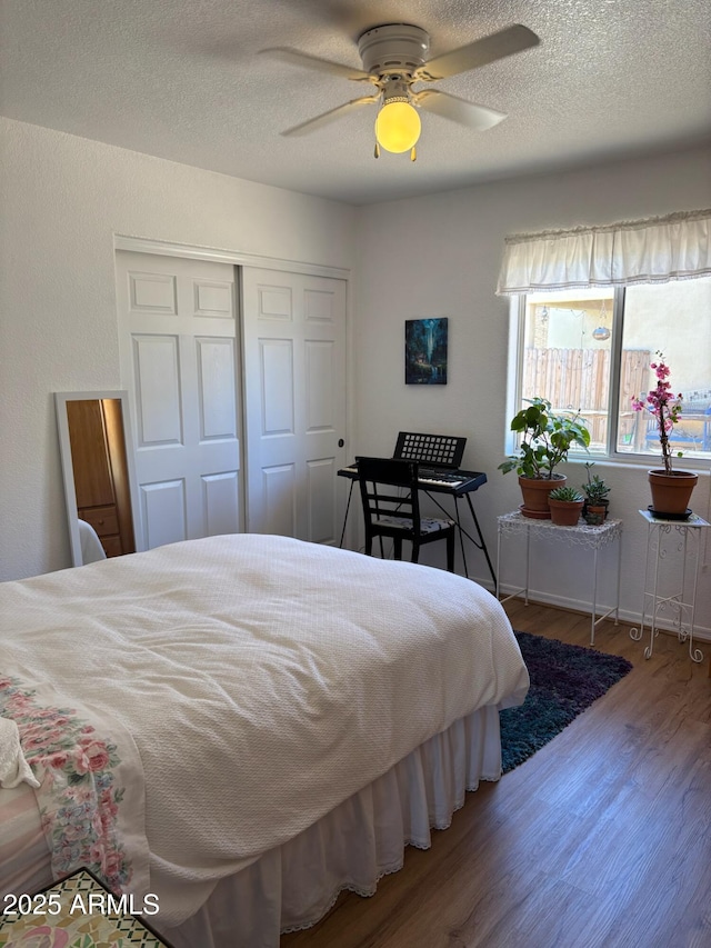 bedroom with ceiling fan, a closet, a textured ceiling, and wood finished floors