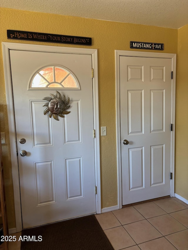 entrance foyer with light tile patterned floors and baseboards