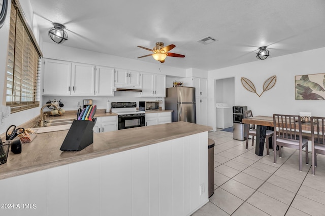 kitchen with stainless steel refrigerator, electric range, sink, kitchen peninsula, and white cabinets