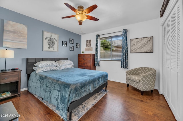 bedroom with dark hardwood / wood-style flooring, ceiling fan, and a closet