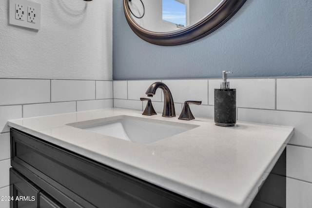 bathroom featuring vanity and tile walls