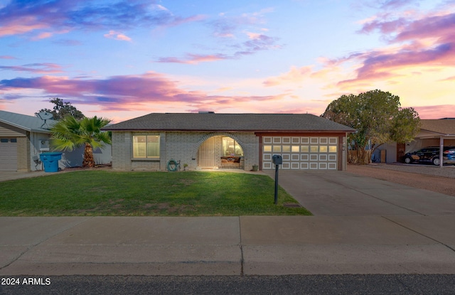 view of front of home with a yard and a garage