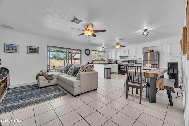 tiled living room with ceiling fan and a textured ceiling