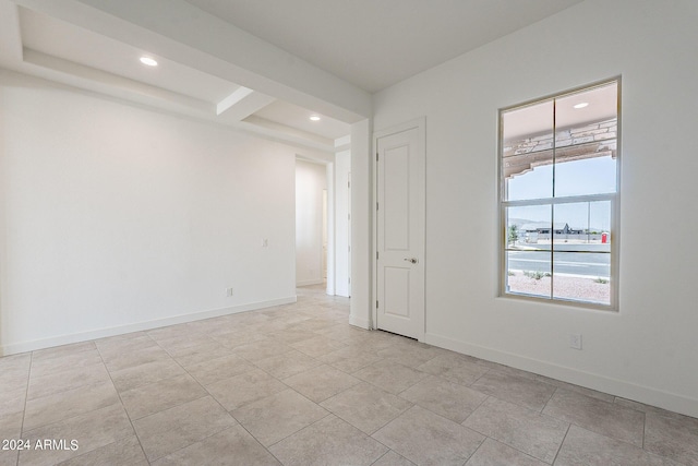 tiled spare room with beam ceiling