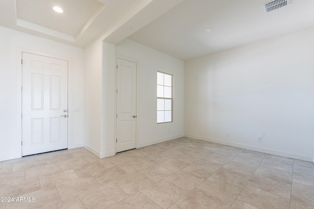 spare room with a raised ceiling