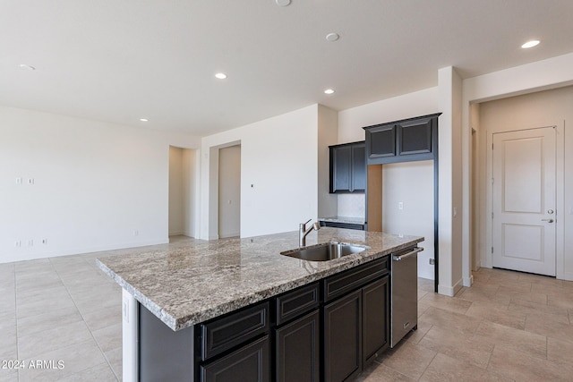 kitchen featuring light stone counters, sink, an island with sink, and stainless steel dishwasher