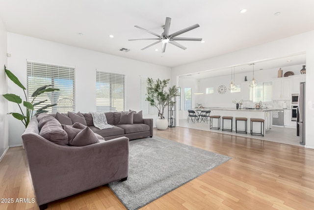 living room featuring ceiling fan and light wood-type flooring