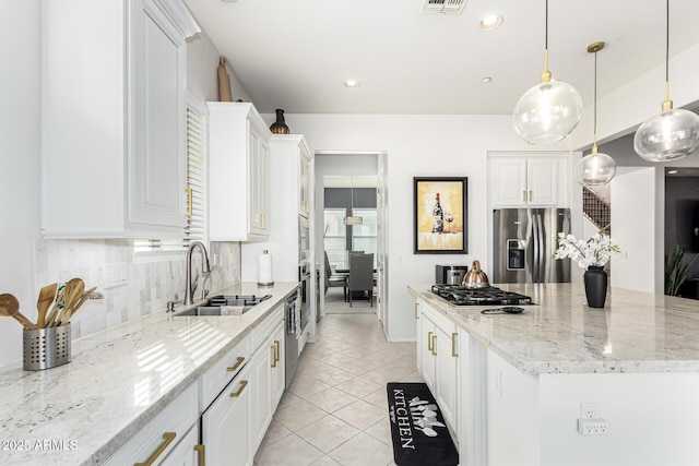 kitchen featuring white cabinetry, stainless steel appliances, decorative light fixtures, and sink