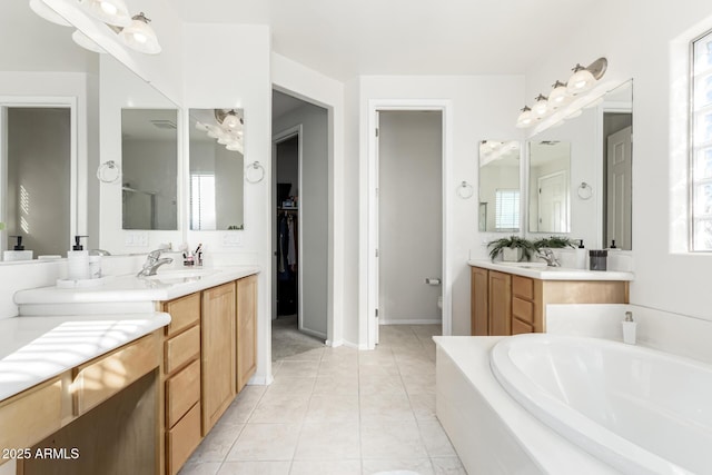 bathroom featuring tile patterned floors, a bathing tub, and vanity