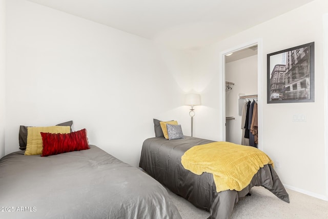 bedroom featuring a walk in closet, carpet floors, and a closet