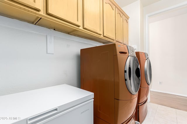 laundry area featuring separate washer and dryer and cabinets