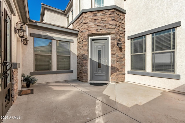 view of exterior entry with a patio area